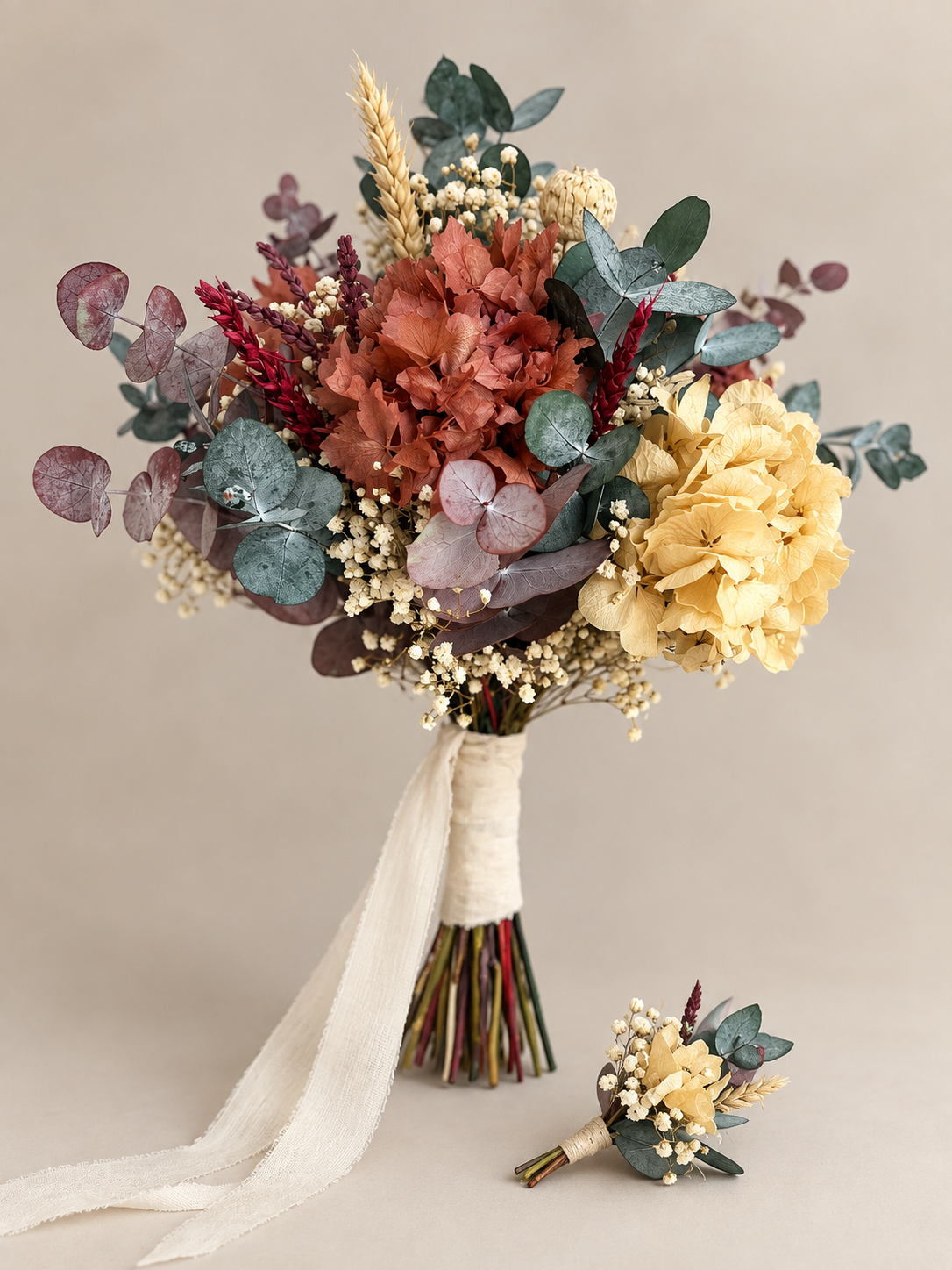 Ramo de flores secas y preservadas en tonos malva, blancoo beige y verde con cinta de tela color marfil.